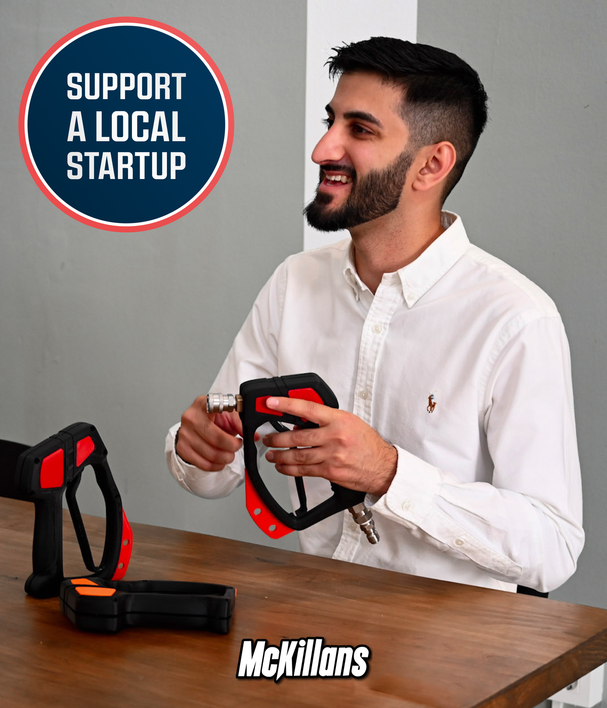 Waheed, founder of McKillans, holding the Swivel Gun Pro with additional pressure washer guns displayed on a table, featuring the message "Support a Local Startup"